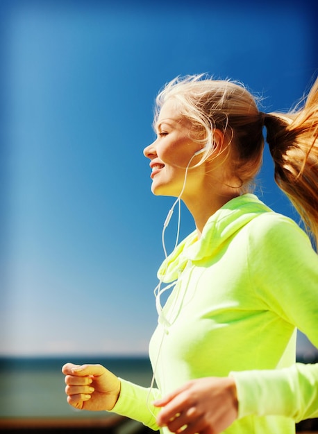 concetto di sport e stile di vita - donna che fa correre all'aperto