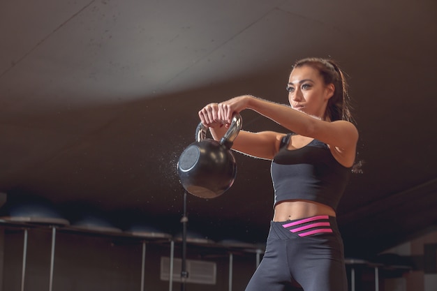 Concetto di sport, fitness, sollevamento pesi e allenamento. gruppo di persone con kettlebell e cardiofrequenzimetri che si esercitano in palestra