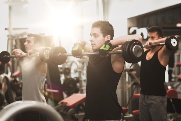 concetto di sport, fitness, stile di vita e persone - gruppo di uomini con bilancieri in palestra