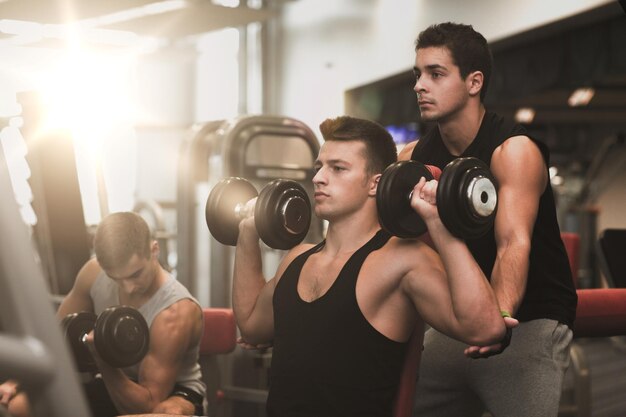 concetto di sport, fitness, stile di vita e persone - gruppo di uomini con manubri in palestra