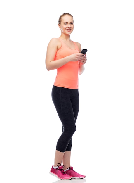 concetto di sport, fitness, tecnologia, stile di vita e persone - giovane donna sportiva sorridente felice con smartphone