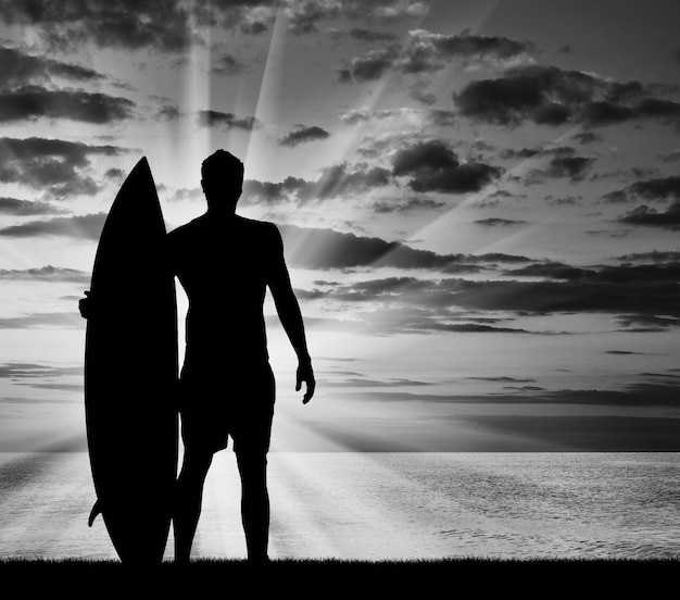 Concetto di sport. Silhouette di surfisti contro il mare la sera