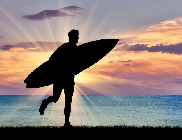 concetto di sport. Silhouette di un surfista sulla spiaggia al tramonto sullo sfondo del mare
