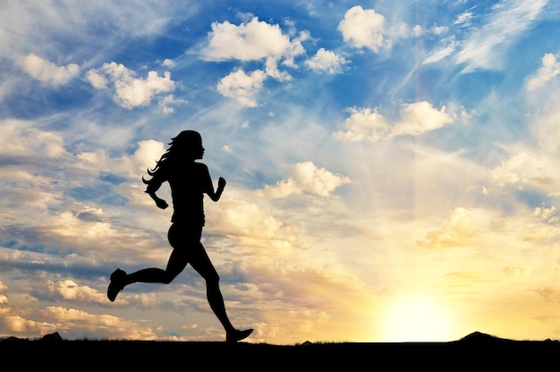 Concetto di sport. Silhouette di una ragazza che corre sullo sfondo di un tramonto