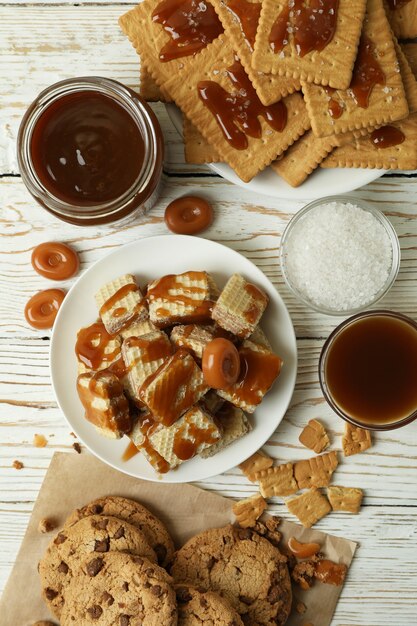 Concetto di spuntino gustoso con i biscotti con caramello sul tavolo di legno bianco