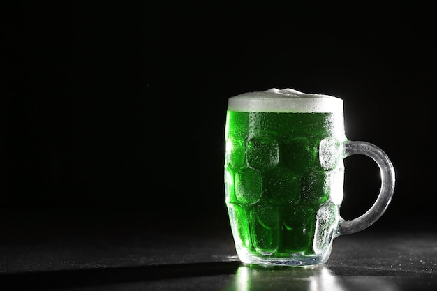 Concetto di St Patrick Day Bicchiere di birra verde su sfondo nero