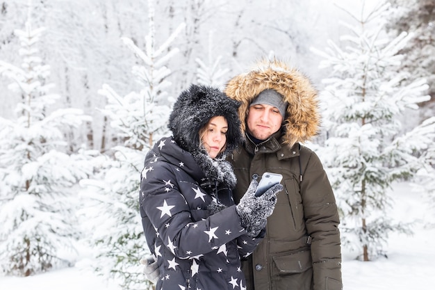 Concetto di stagione e relazione - Coppie divertenti che prendono selfie nel periodo invernale