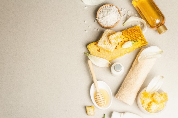 concetto di stazione termale. Cura di sé con miele, sale marino e panna. Cosmetici biologici naturali, prodotti fatti in casa, stile di vita alternativo. Sfondo di pietra chiara, vista dall'alto