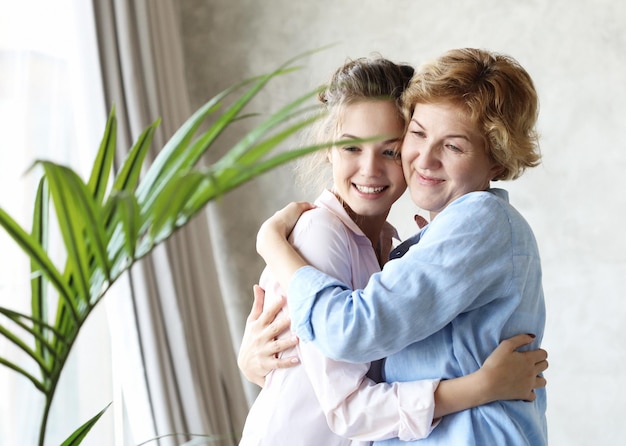 Concetto di stile di vita e persone Felice madre senior che abbraccia la figlia adulta che ride insieme