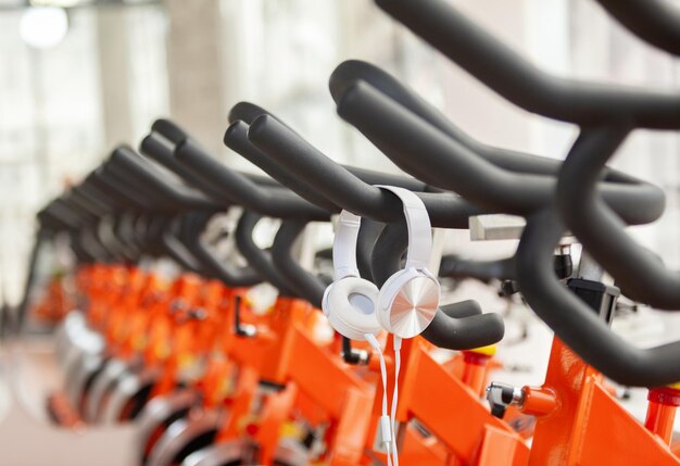 Concetto di stile di vita sano Classe di spinning con biciclette e cuffie vuote Allenamento sportivo fitness