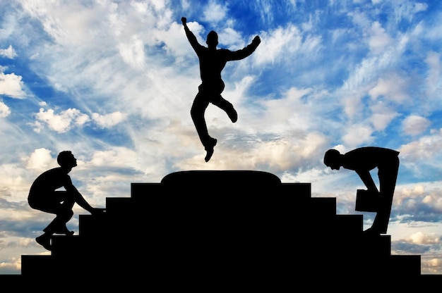 Concetto di successo aziendale. Silhouette di un uomo d'affari felice che salta in cima ai gradini e alla competizione