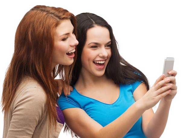 concetto di tecnologia, amicizia e persone - due adolescenti sorridenti con smartphone