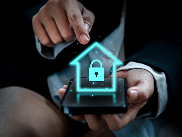 Concetto di tecnologia domestica intelligente Ologramma simbolo di blocco domestico di sicurezza digitale incandescente che appare sullo smartphone nelle mani dell'uomo d'affari App di controllo dell'automazione del sistema di sicurezza Smarthome