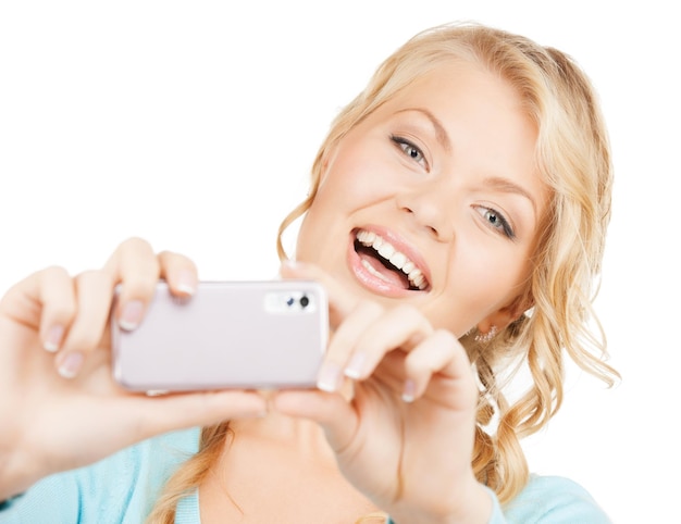concetto di tecnologia - donna sorridente che prende foto con lo smartphone