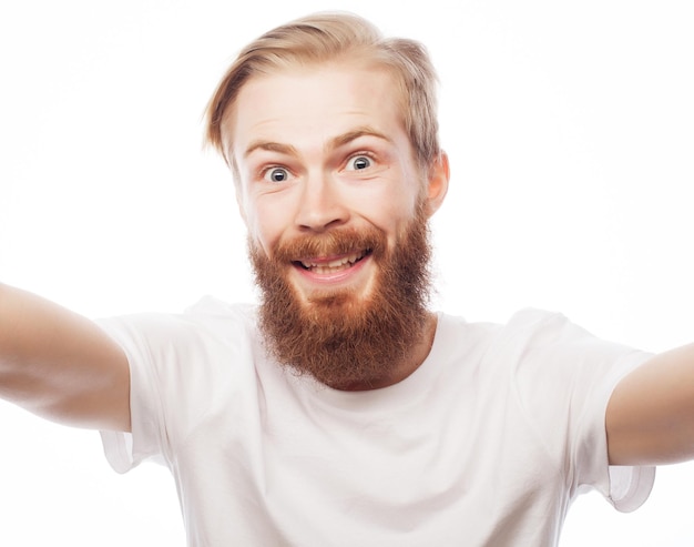 Concetto di tecnologia: selfie felice. Bel giovane che tiene la macchina fotografica e fa selfie e sorride.