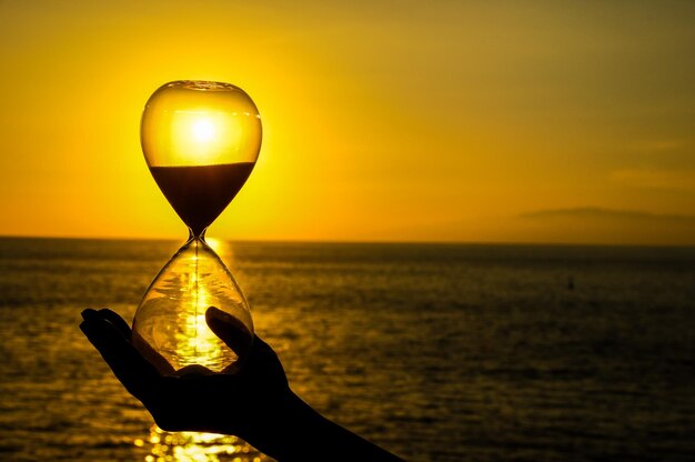 Concetto di tempo Clessidra e tramonto sull'Oceano Atlantico