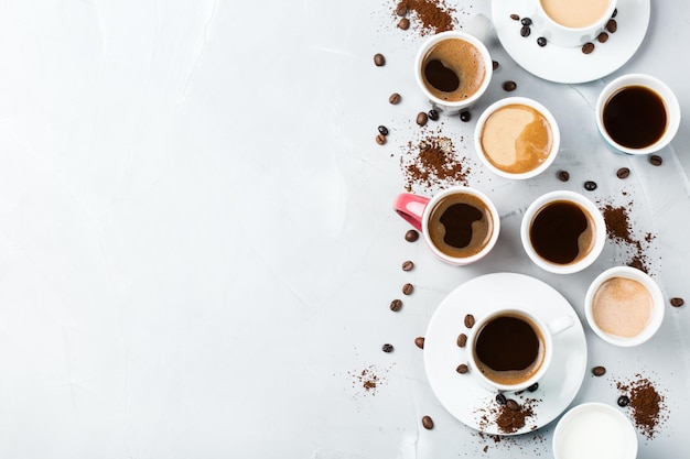 Concetto di tempo di relax per la colazione Tazze e tazze da caffè diverse su un accogliente tavolo da cucina Spazio per la copia vista dall'alto sfondo piatto