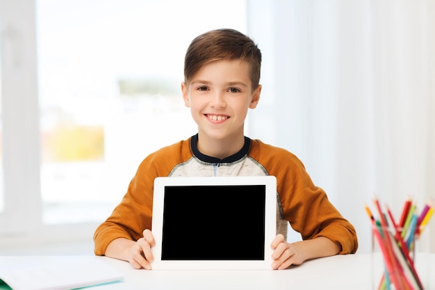 concetto di tempo libero, bambini, tecnologia, istruzione e persone - ragazzo sorridente che mostra lo schermo del computer tablet pc vuoto a casa