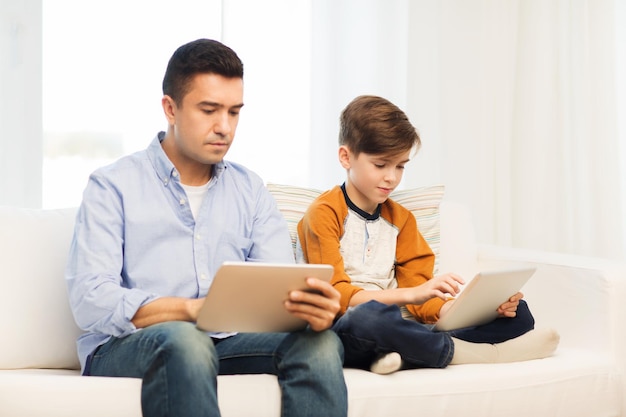concetto di tempo libero, tecnologia, tecnologia, famiglia e persone - padre e figlio con computer tablet pc in rete o giocare a casa