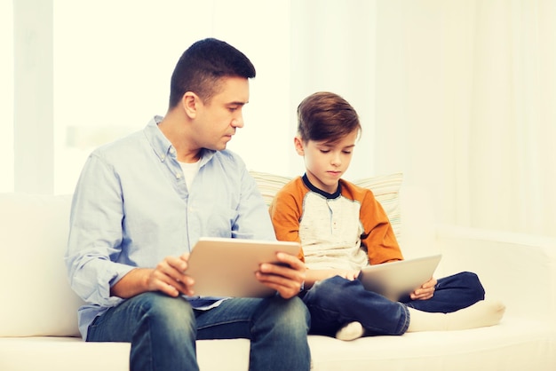 concetto di tempo libero, tecnologia, tecnologia, famiglia e persone - padre e figlio con computer tablet pc in rete o giocare a casa