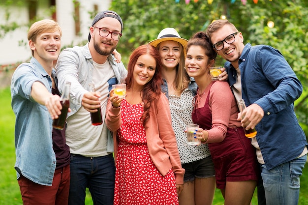 concetto di tempo libero, vacanze, persone, riunione e celebrazione - amici felici con drink alla festa estiva in giardino