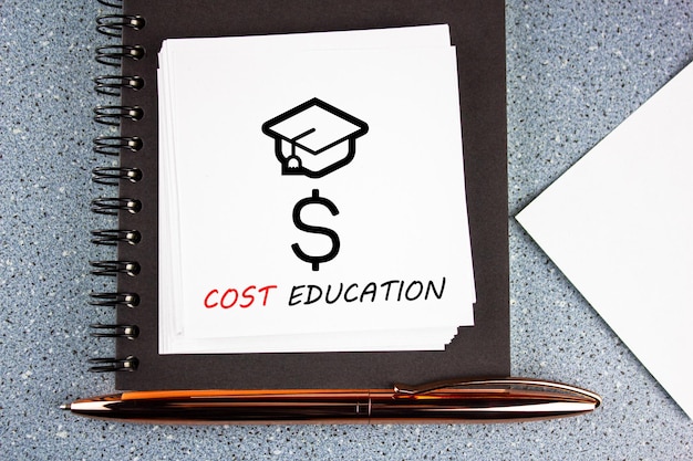 Concetto di testo di educazione ai costi con tappo laureato e simbolo del dollaro Il concetto di costo dell'istruzione