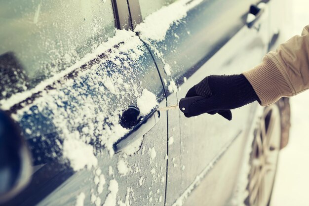 concetto di trasporto e proprietà - primo piano della mano dell'uomo che apre l'auto con la chiave