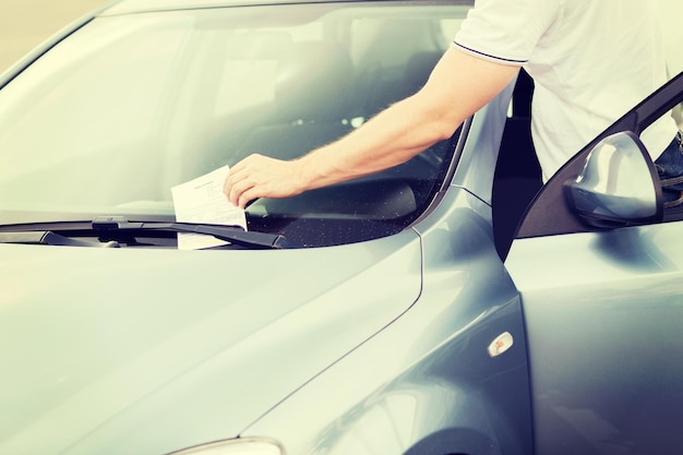 concetto di trasporto e veicolo - biglietto di parcheggio sul parabrezza dell'auto