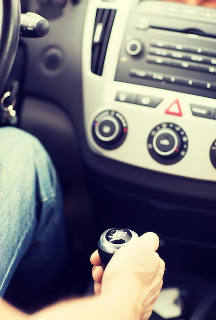 concetto di trasporto e veicolo - uomo che cambia la marcia sul cambio manuale dell'auto