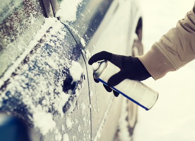 concetto di trasporto, inverno e veicolo - primo piano della mano dell'uomo con serratura antighiaccio