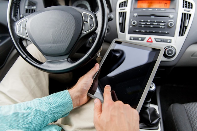 concetto di trasporto, viaggio d'affari, tecnologia e persone - primo piano di un giovane con computer tablet pc che guida l'auto