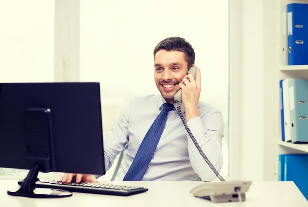 concetto di ufficio, affari, istruzione, tecnologia e internet - uomo d'affari sorridente o studente con computer e telefono