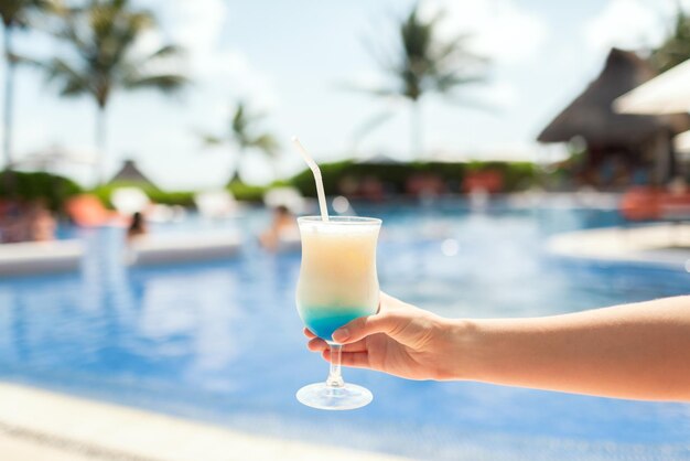 concetto di vacanza, bevanda e viaggio - primo piano della mano femminile che tiene il bicchiere con cocktail