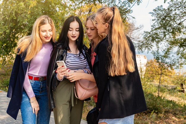 Concetto di vacanza, di feste, di viaggio e della gente di vacanze estive - gruppo di giovani donne nel parco