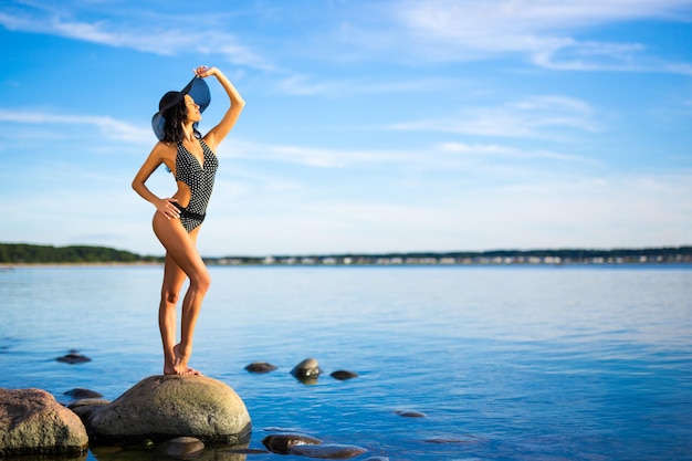 Concetto di vacanza estiva e di viaggio sottile bella donna in bikini in posa sulla spiaggia