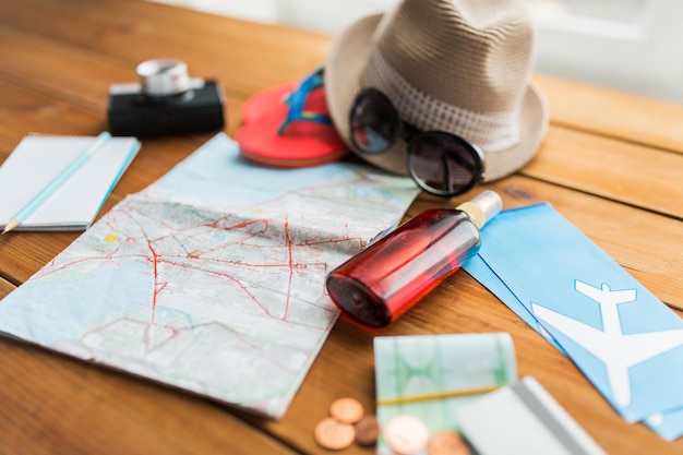 concetto di vacanza estiva, turismo e oggetti - primo piano della mappa di viaggio, biglietti aerei, denaro e accessori personali