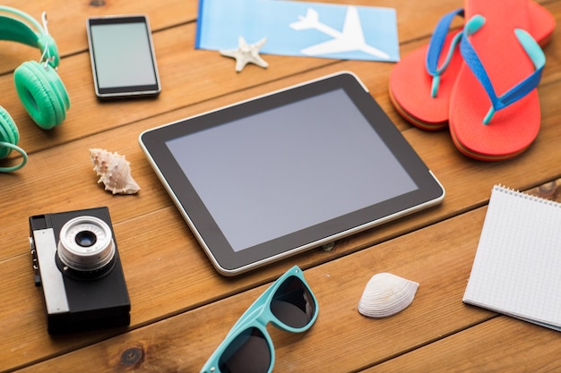 concetto di vacanza, viaggio, turismo, tecnologia e oggetti - primo piano del computer tablet pc e roba da viaggio