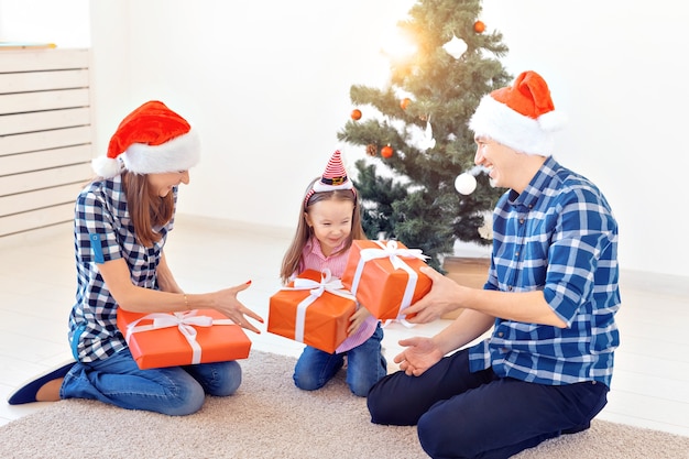 Concetto di vacanze e regali - Ritratto di una famiglia felice che apre i regali nel periodo natalizio.