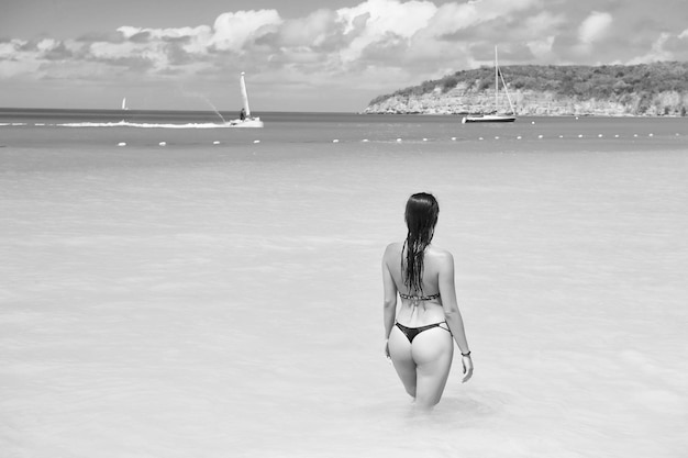 Concetto di vacanze vacanze estive Donna in bikini sexy sulla spiaggia del mare ad antigua Ragazza sensuale nell'acqua blu del mare o dell'oceano in una giornata di sole Viaggio in viaggio Wanderlust Resort benessere riposo sano