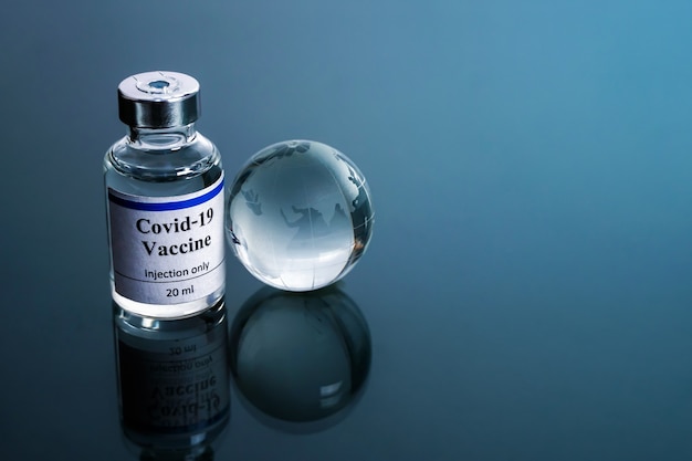 concetto di vaccinazione Globe Glass con bottiglia di vaccino coronavirus