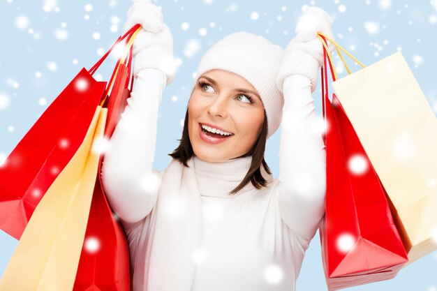 concetto di vendita al dettaglio e vendita - donna felice in abiti invernali con borse della spesa