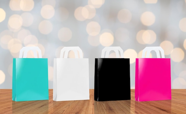 concetto di vendita, consumismo e pubblicità - molte borse della spesa vuote di colore blu, bianco, nero e rosa su sfondo di luci natalizie