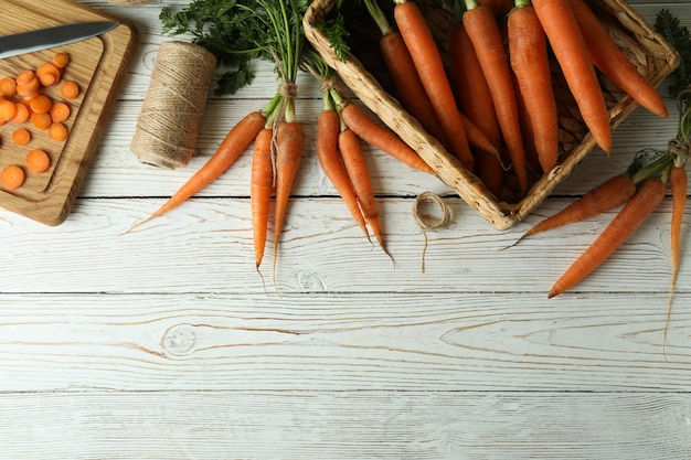 Concetto di verdura fresca con carota su superficie di legno bianca