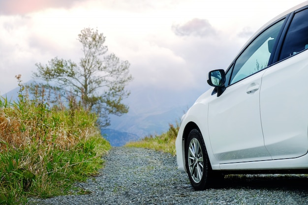 Concetto di viaggio Auto sulla strada in campagna, guida auto in cielo nuvoloso e montagna