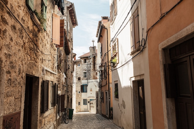 Concetto di viaggio estivo. Vista sulla città vecchia dell'Europa, Croazia, Rovigno. Strada vuota con vecchi edifici con persiane.