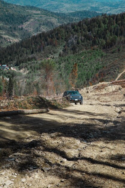 Concetto di viaggio in auto suv che guida su una strada di campagna che porta alle montagne