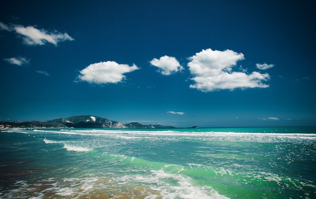 Concetto di viaggio - spiaggia con nuvole e cielo blu