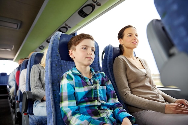 concetto di viaggio, turismo, famiglia, tecnologia e persone - madre e figlio felici che viaggiano in autobus da viaggio