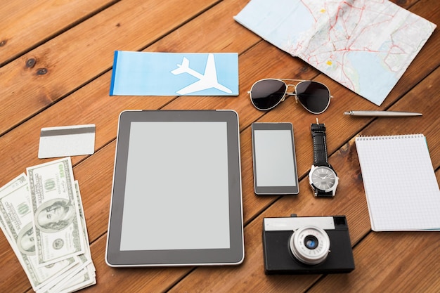 concetto di viaggio, turismo, tecnologia e oggetti - primo piano di smartphone con computer tablet pc, biglietto aereo e cose personali