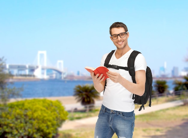 concetto di viaggio, vacanza e istruzione - studente in viaggio con zaino e libro